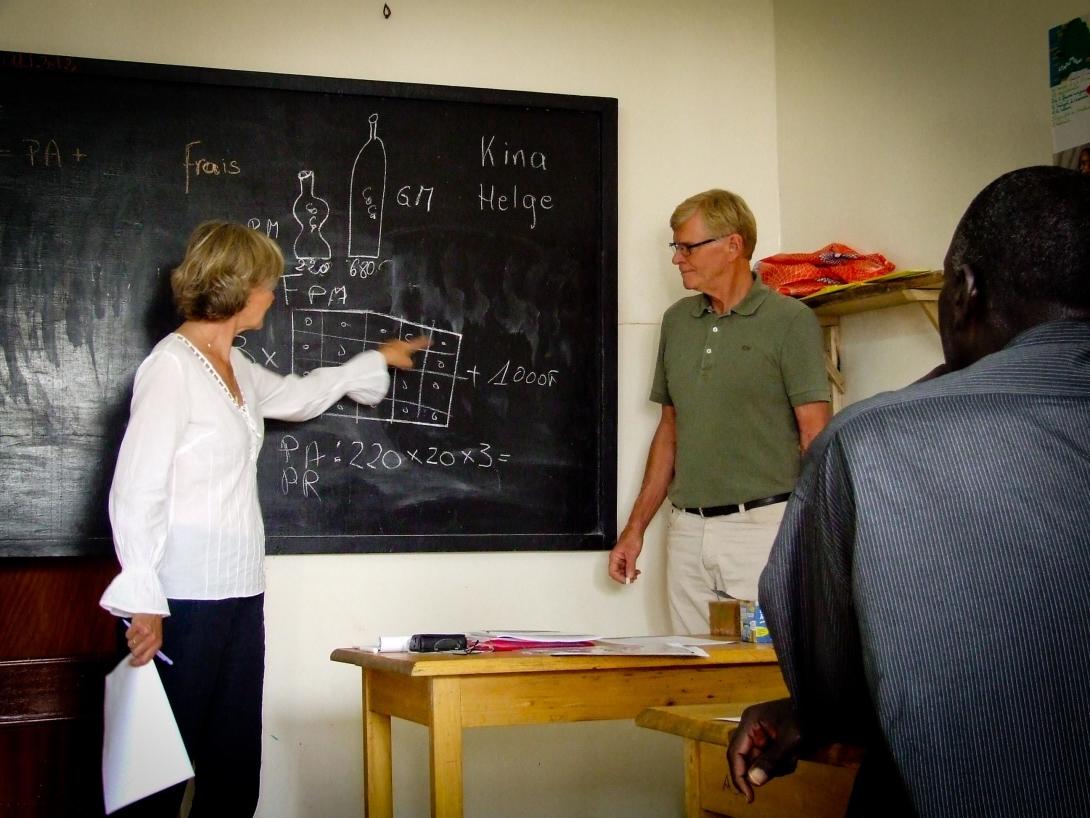 A female and male volunteer teaching in a micro finance project in Tanzania.
