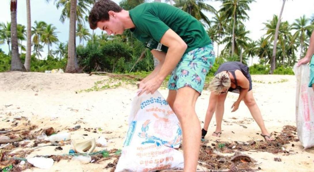 Volunteers clean a beach of trash and fishing nets