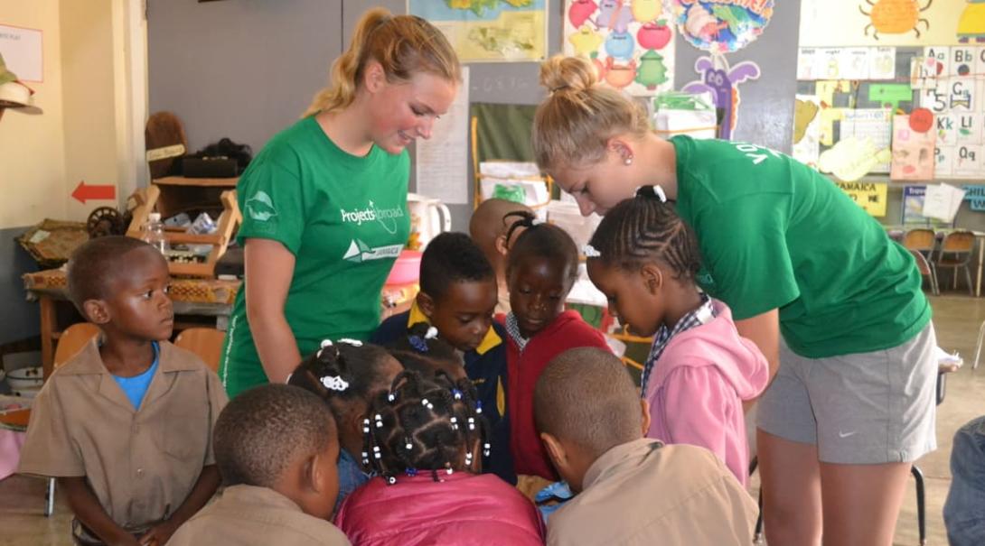 Childcare volunteers in Jamaica helping school children