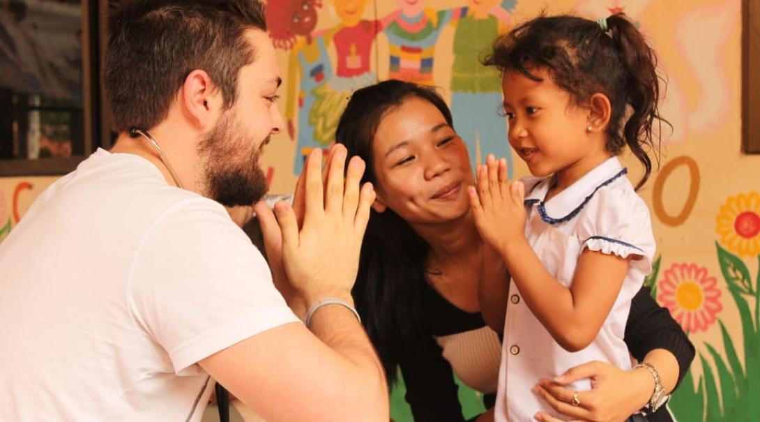 Public Health intern with a child in Cambodia