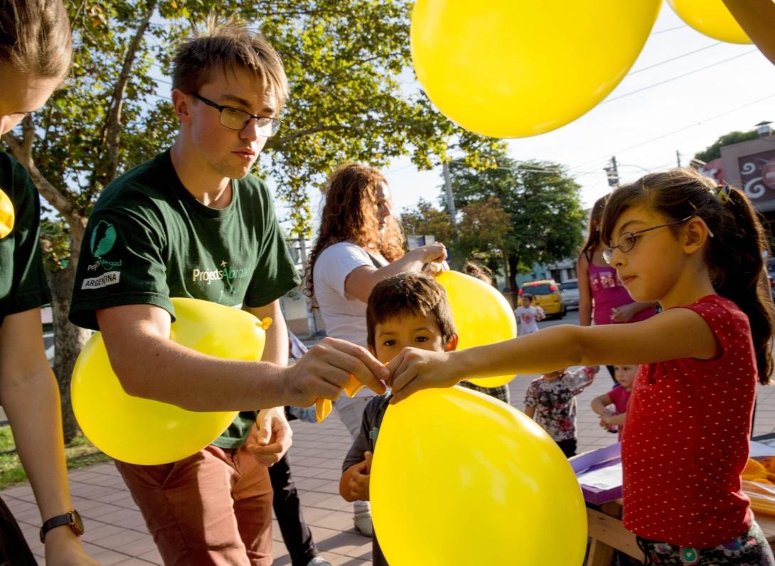 	Projects Abroad volunteer passes balloons out to children in Plaza Geronimo del Barco in Cordoba during a campaign against human trafficking put on with local NGO, Basta de Trata.