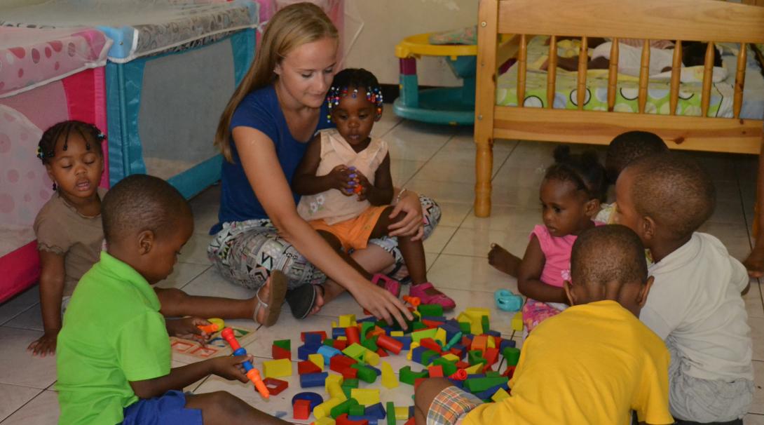 Childcare volunteer with a group of young children in Jamaica