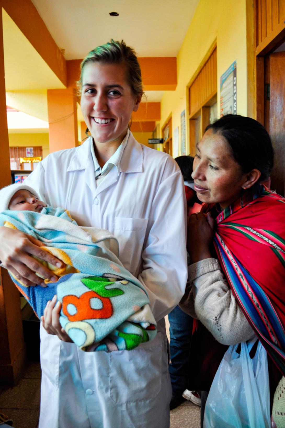 Medical volunteer holding a baby in Peru