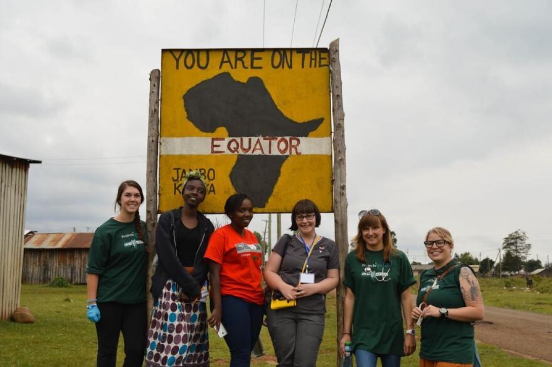Last-minute volunteers in Kenya, by a sign in Nanyuki