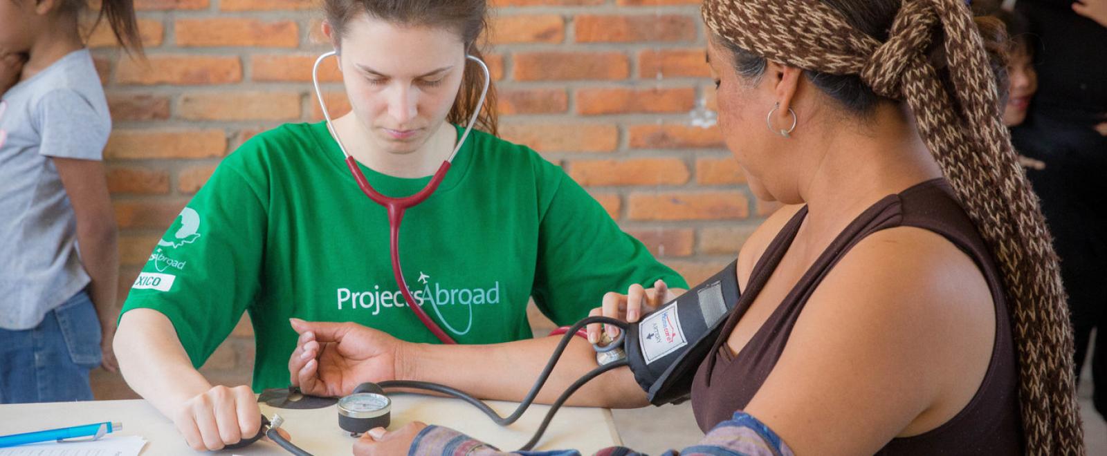 A medical volunteer in Mexico checks a patient's blood pressure during a healthcare outreach. 