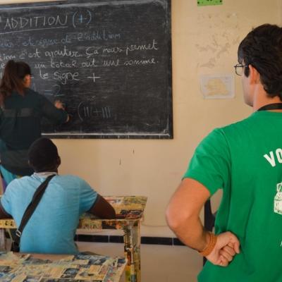 Projects Abroad volunteers provide a local business owner with math lessons in Senegal