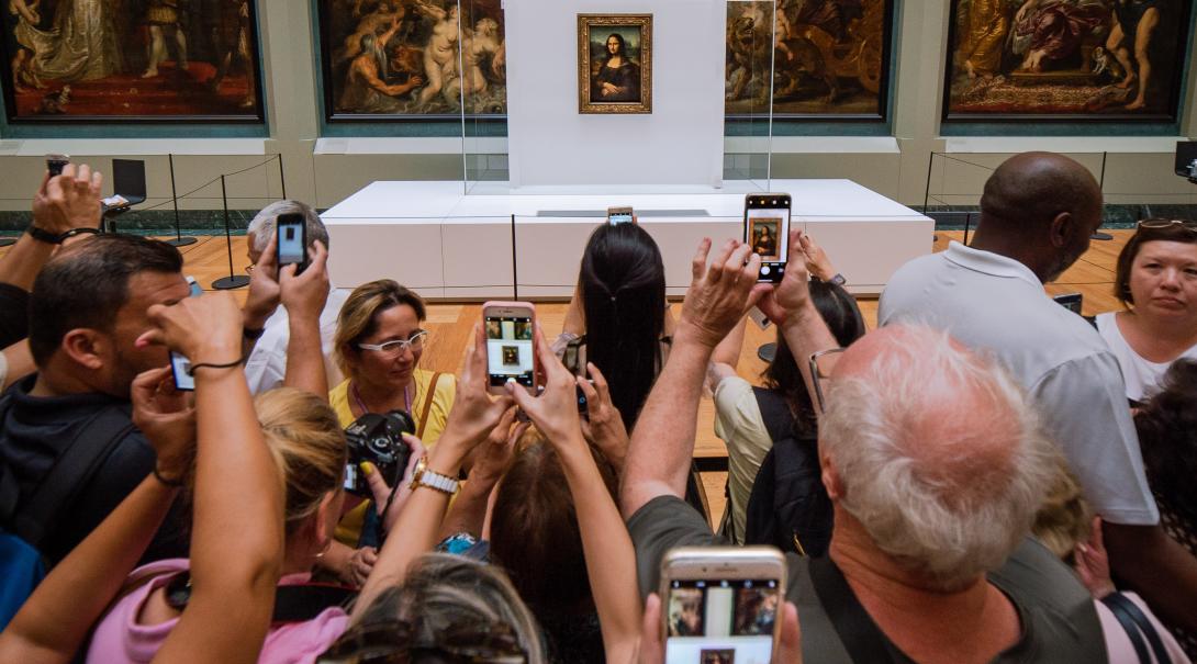 A crowd gathers around the Mona Lisa