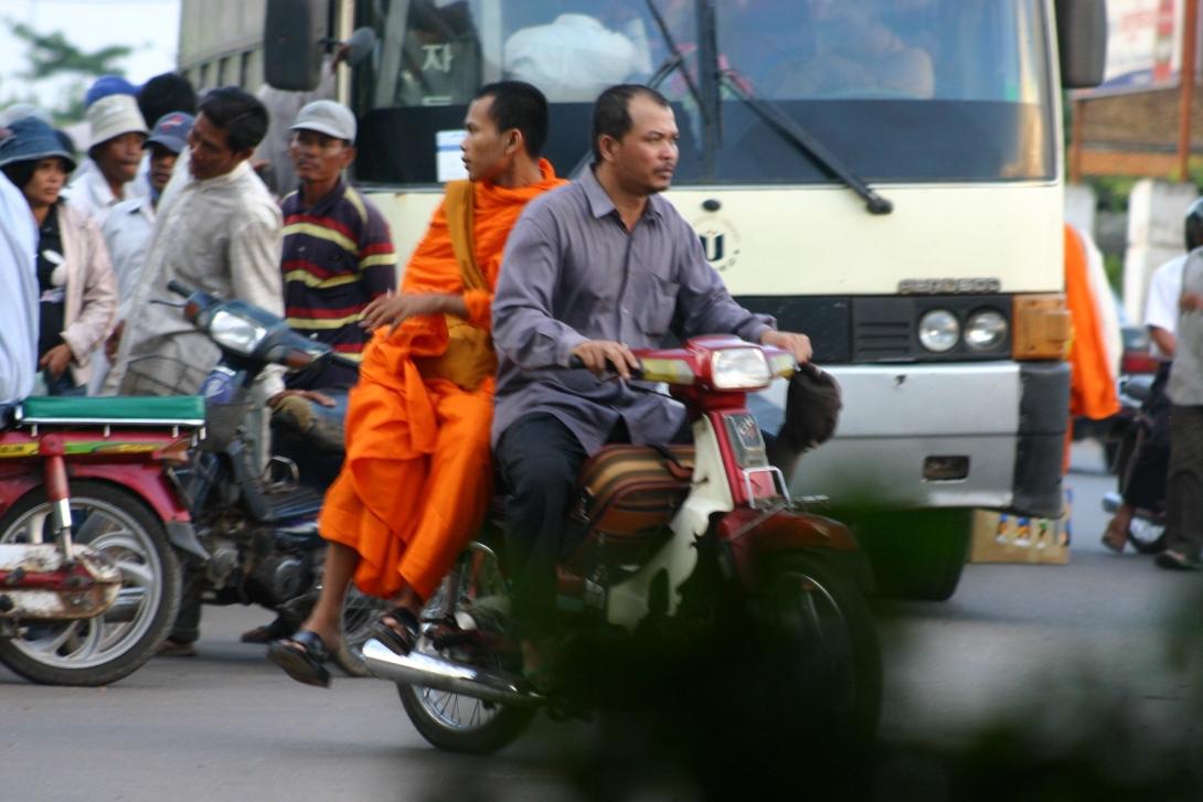 Buddhist monk driven by a moto taxi in Cambodia