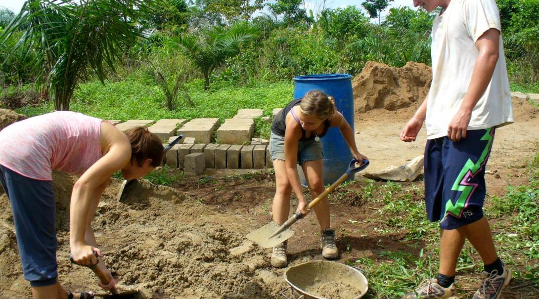 Projects Abroad volunteers can be seen participating in preparing the building site during their building volunteer work in Ghana.