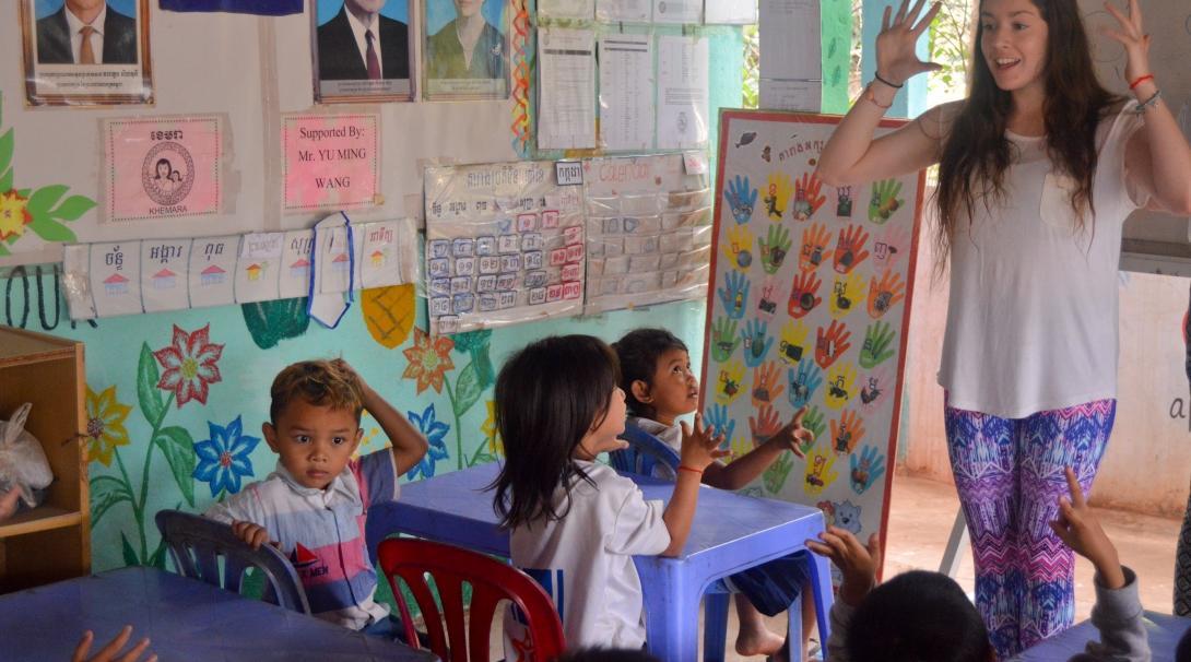 Projects Abroad Childcare volunteer helps children improve their English skills a a local community centre in Cambodia.