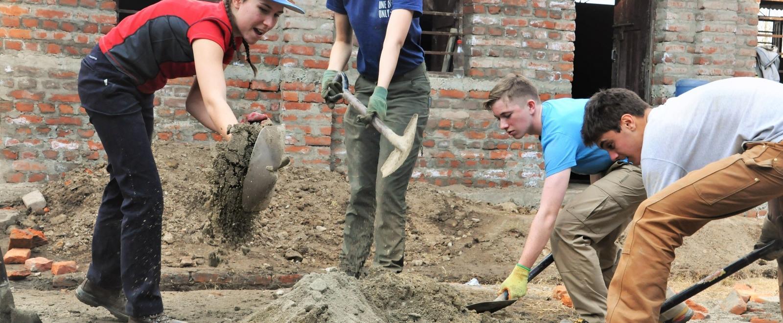 Volunteers in Nepal dig up sand for cement to help rebuild schools as part of their construction volunteer project.