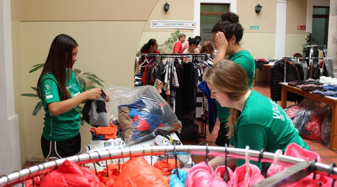 Female Interns are sorting through bags of clothes at a clothes companies store during their work placement in Mexico. 