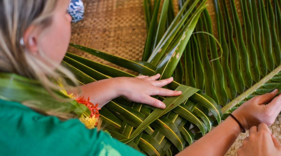 Female Culture and Community Volunteer weaves leaves during her volunteering placement in Fiji.
