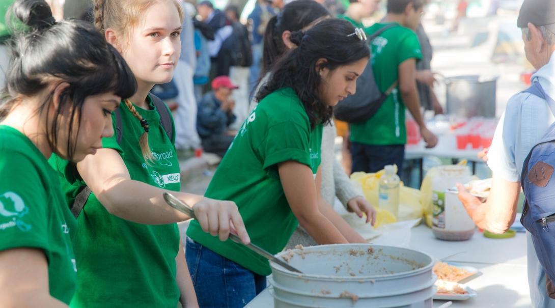 Female International Development Interns serve food at a shelter for immigrants at their work placement in Mexico.