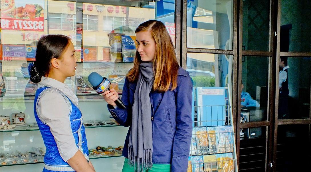 A journalism intern in Mongolia speaks to a woman in the street
