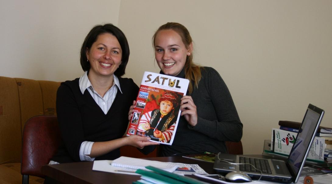 An intern holds up a magazine at a journalism placement in Romania 