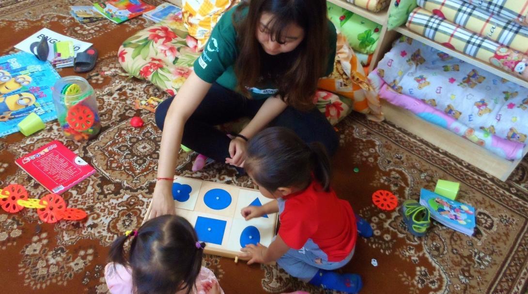 Projects Abroad Childcare volunteer teaches children shape games in a care centre during a Psychology work experience in Mongolia.