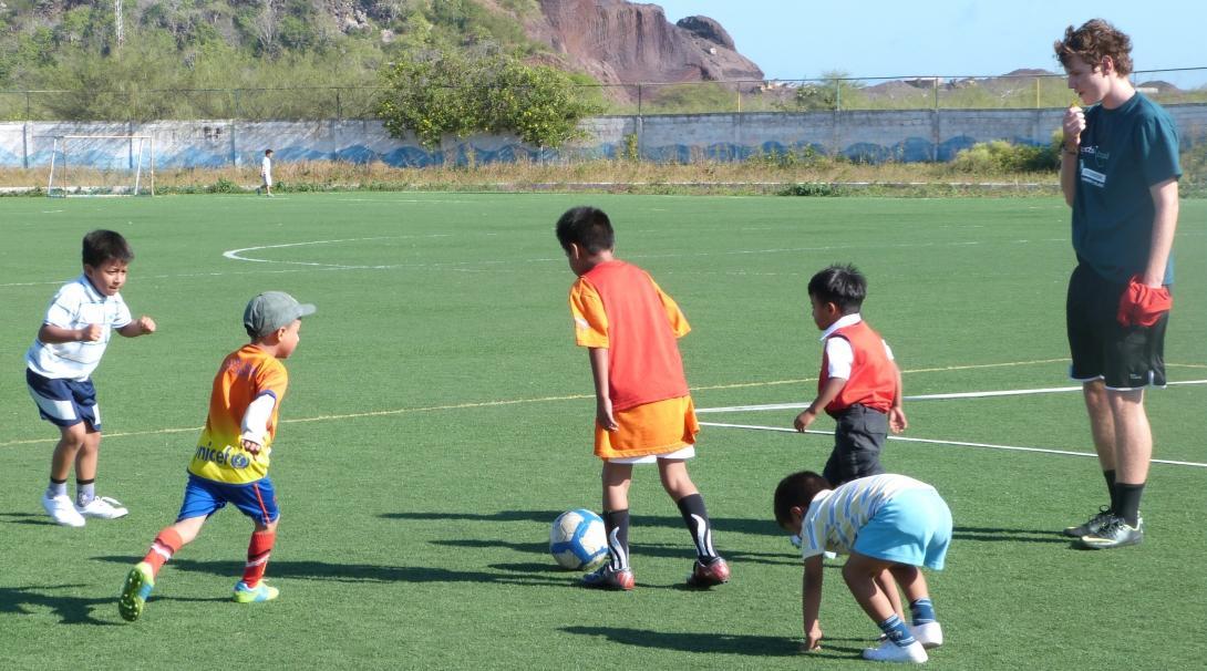 A sports instructor volunteers as a sports coach in Ecuador and leads a football practice