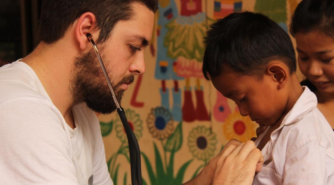 Cambodian child is treated by a male medical intern during a local outreach programme.
