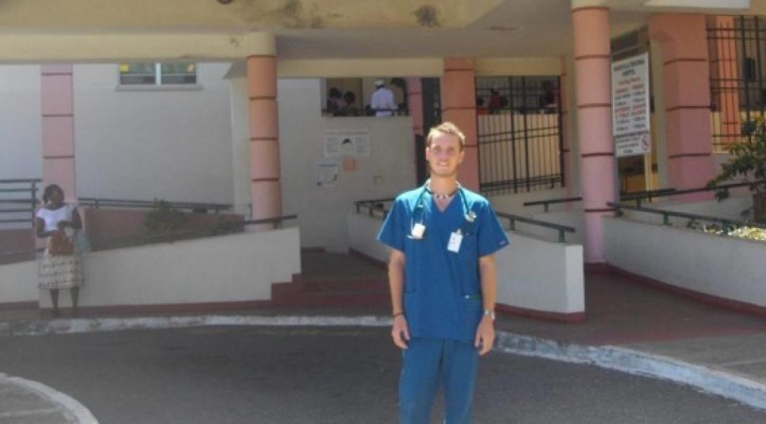Male Medical intern stands outside Mandeville Hospital in Jamaica during his Medicine Internship.