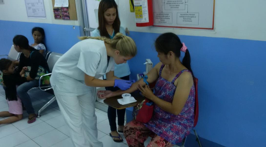 A doctor and Projects Abroad intern draw blood from a patient whilst on her medical internship in the Phillippines.