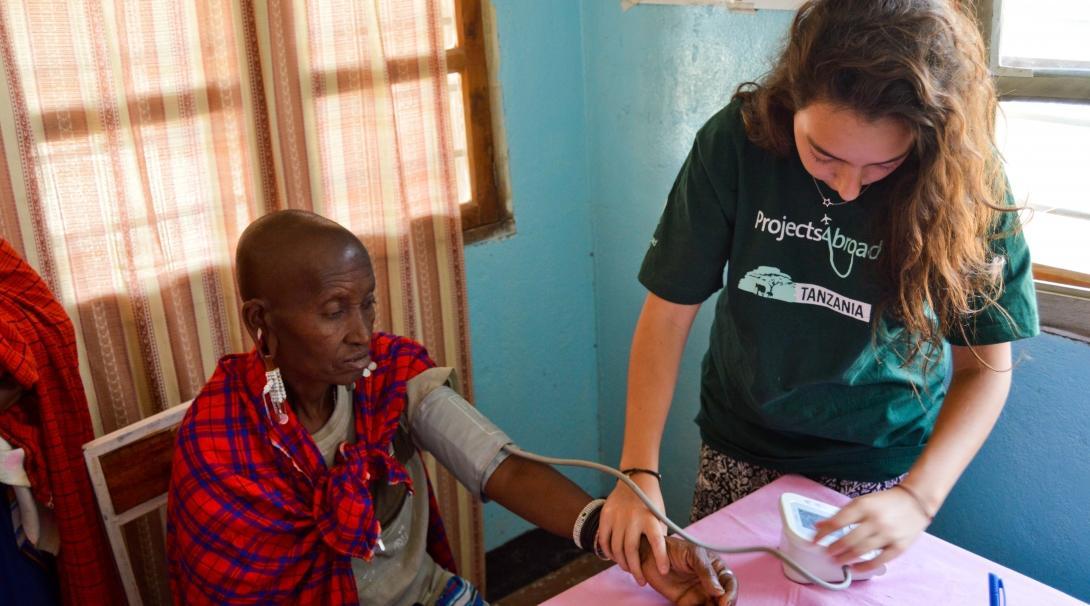 Projects Abroad intern takes the blood pressure of local residents during her medicine internship in Tanzania.