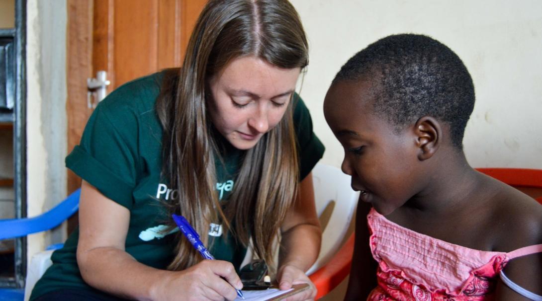 An intern from Projects Abroad is seen taking down the details of a young girl at a local surgery during her medical internship in Tanzania. 