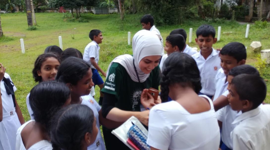 Projects Abroad intern is pictured greeting a group of children at a medical outreach during her nursing internship in Sri Lanka.
