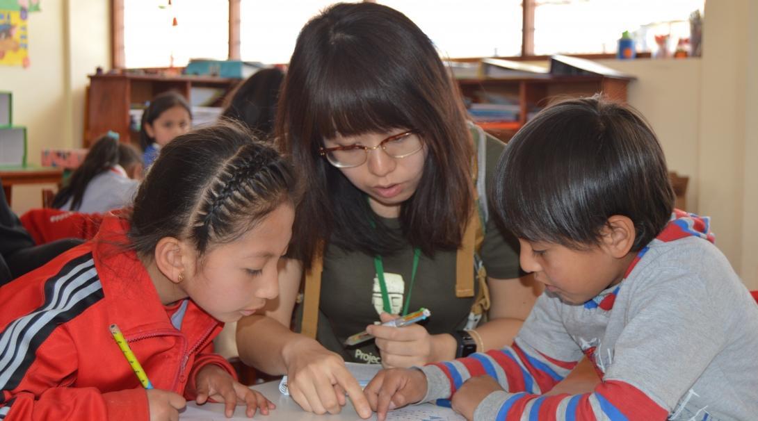 Teenage volunteers doing work with children in Peru, help in the classroom with activities.  