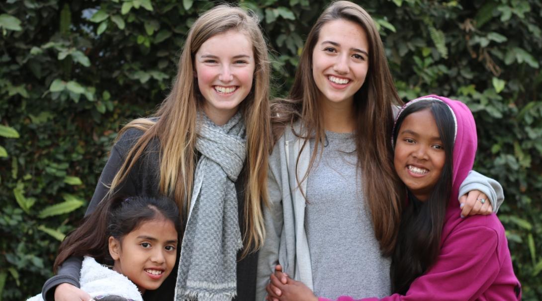 Teenage volunteers doing work with children in Nepal, take a photo with their students. 