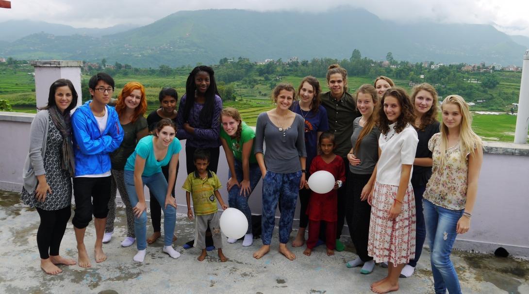 Teenage volunteers doing work with children in Nepal, take a photo with children.   