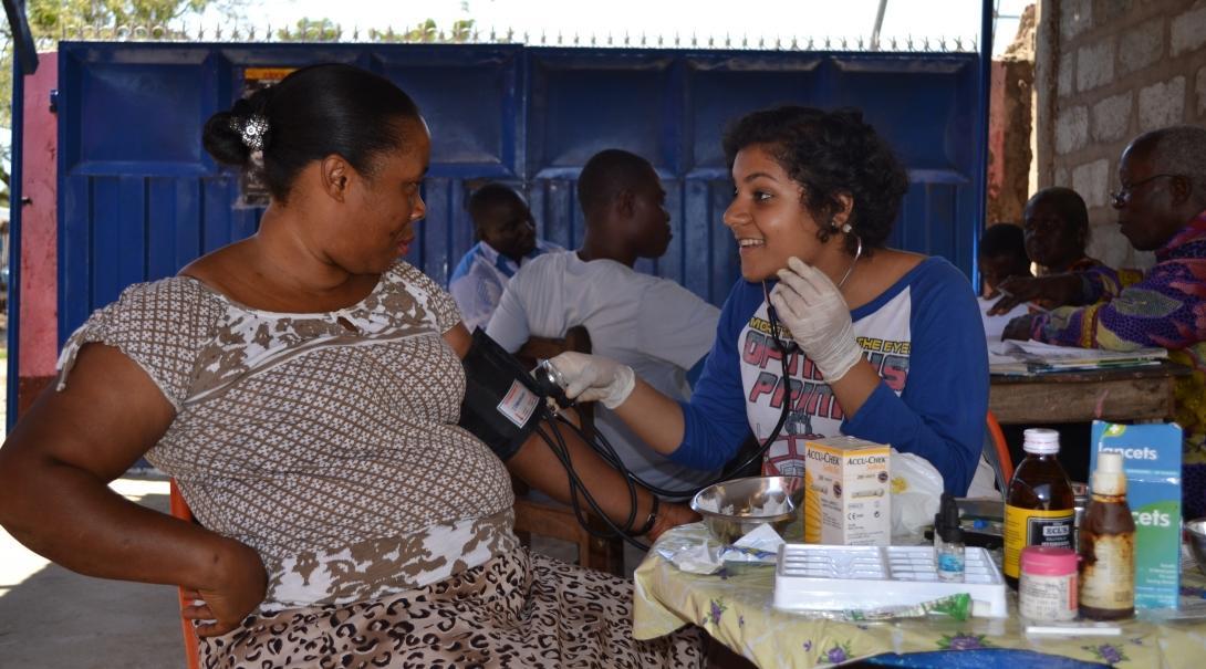 A female Projects Abroad intern is pictured performing a check up on a local woman as part of her midwifery internship in Ghana.