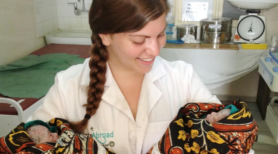 An intern photographed holding newly born twins whilst on her midwifery internship in Tanzania with Projects Abroad.