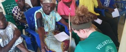 A student doing a Nursing internship in Ghana with Projects Abroad treats a local woman during a medical outreach.
