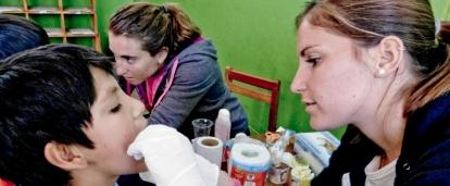 A projects abroad intern is seen giving a check up to a local boy whilst on her nursing work experience in Peru.