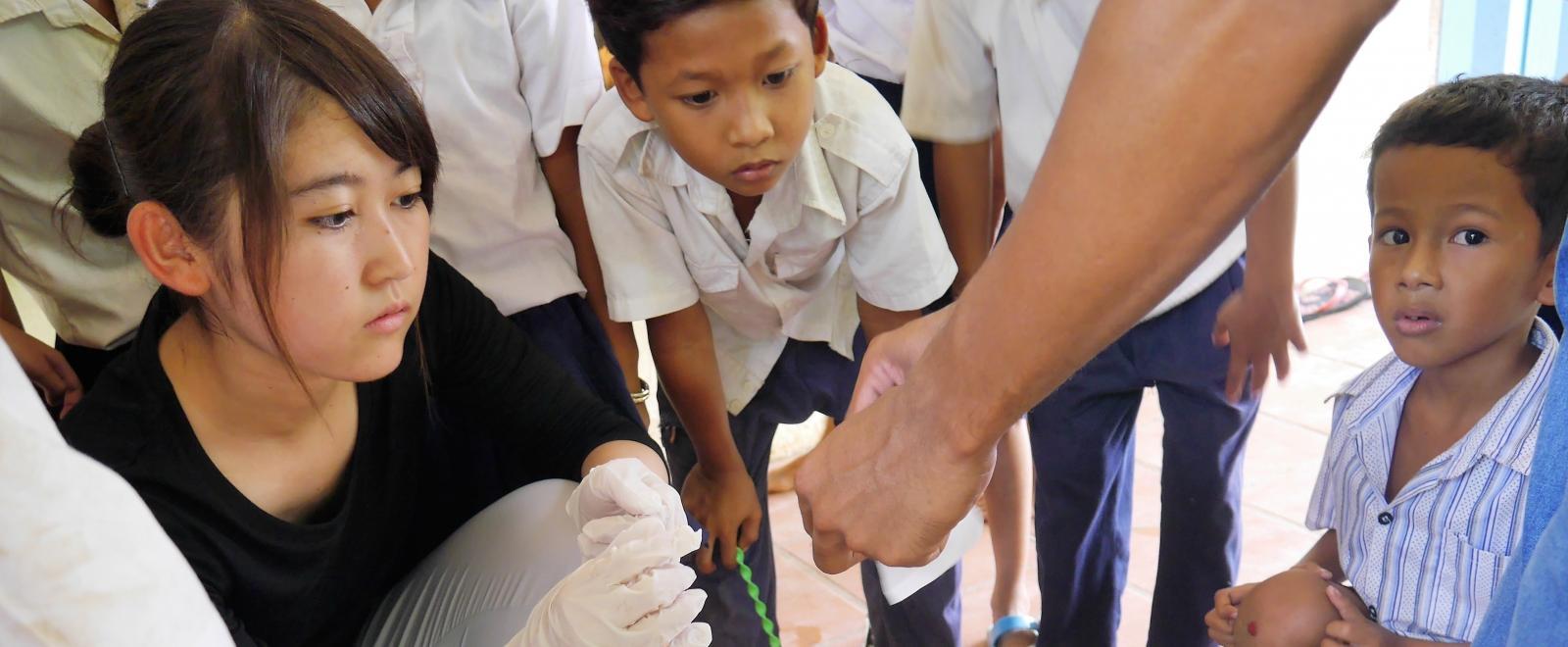 A female intern is pictured taking part in testing blood sugar levels whilst on her public health internship in Cambodia.