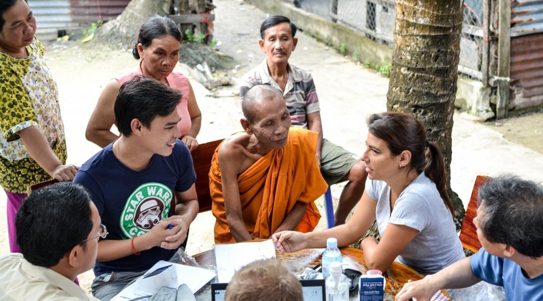 An intern is seen talking to locals during an outreach whilst she completes her public health internship in Cambodia with Projects Abroad.
