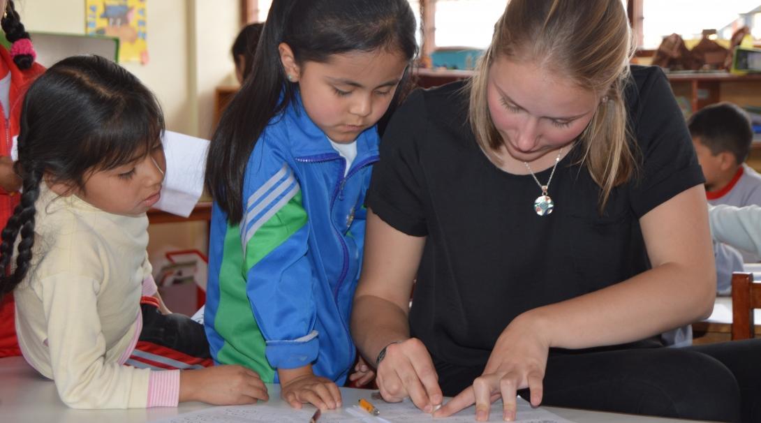 Teaching volunteer in Peru explains to her student where she went wrong in her work and how to correct it