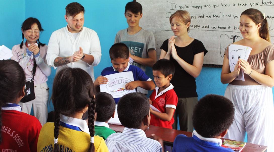 Projects Abroad volunteers teaching in Nepal encourage a student to present to the class in English during a dental hygiene lesson