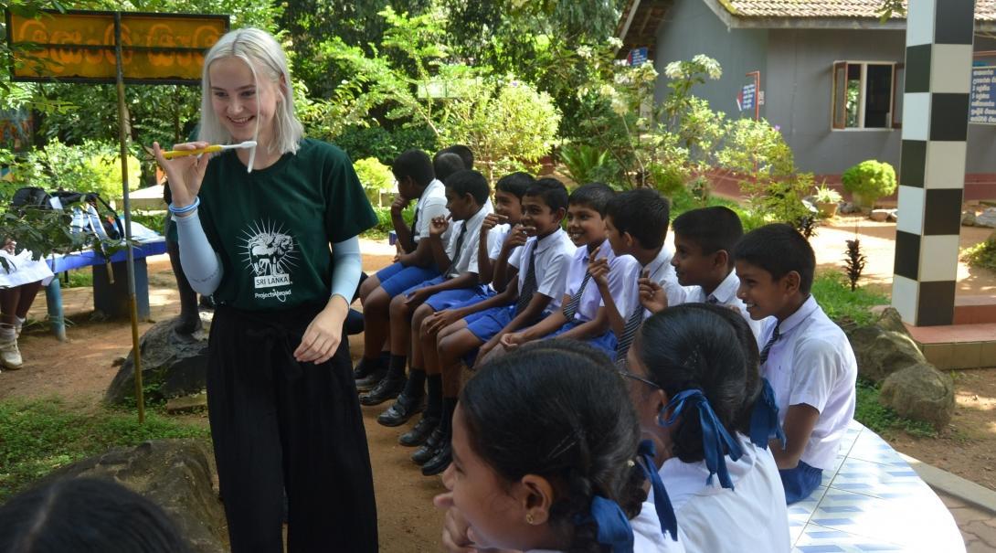 Female Dentistry intern teaches a group of school children about good dental hygiene during her Dentistry placement in Sri Lanka.