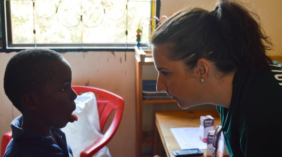 A young boy has his mouth and throat examined by a Projects Abroad Dentistry intern during an outreach in Tanzania.