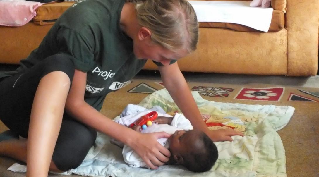 A Projects Abroad intern is pictured interacting with a baby whilst on her occupational therapy internship in Kenya.