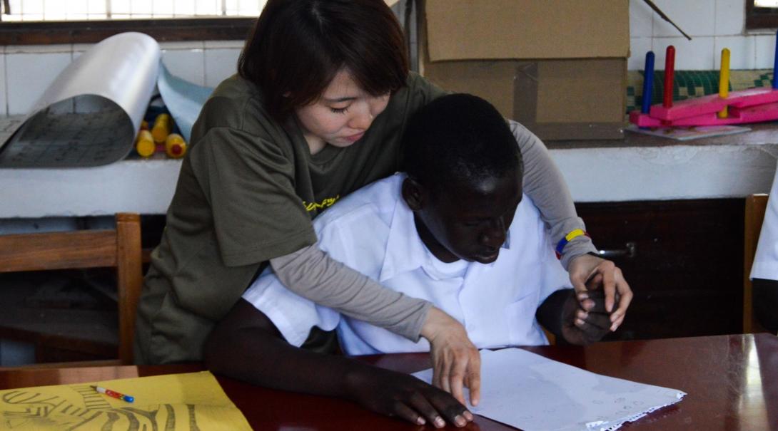 Projects Abroad experienced intern is pictured helping a boy learn to draw whilst on her medical occupational therapy internship in Tanzania.