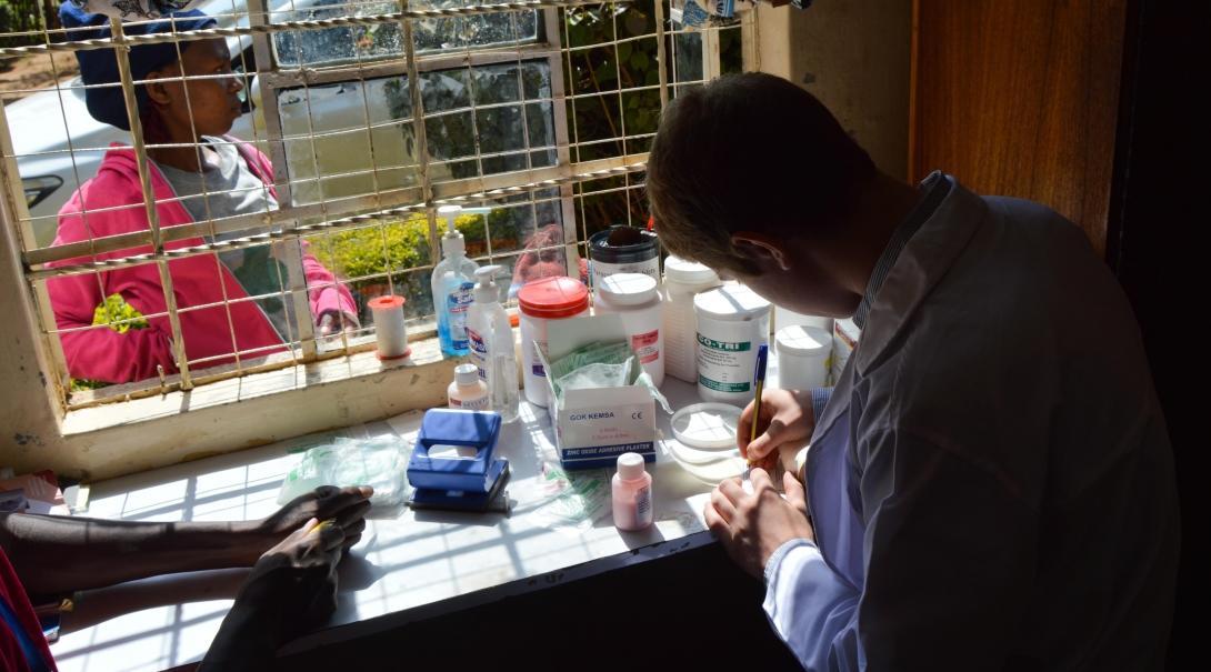 A local doctor is pictured organising medical prescriptions whilst a placement student with projects abroad whilst on her pharmacy internship in Ghana watches over.