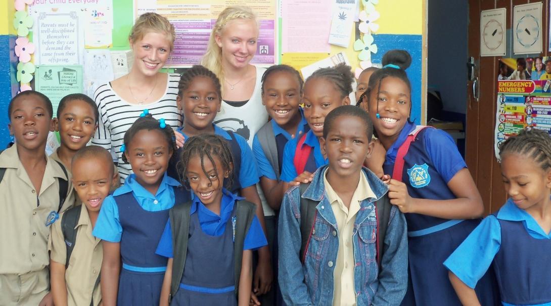 Projects Abroad volunteers teaching in Jamaica pose with their students