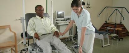 Female intern from Projects Abroad giving phsyiotherapy to a local man during her physiotherapy work experience in Ghana.