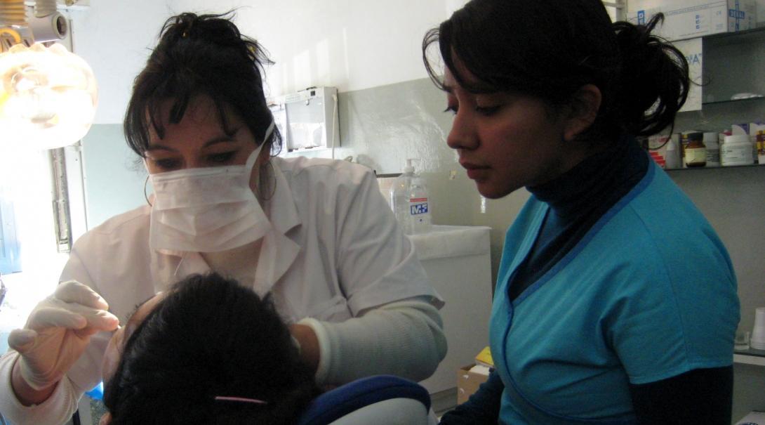 A dentist explains a dental procedure to a student doing a Dentistry internship in Argentina.