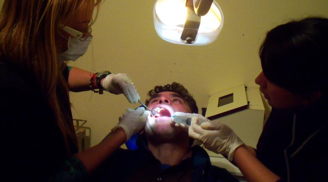 Projects Abroad Dentistry worker examines a patients mouth with a dentist during Dentistry work experience in Argentina.