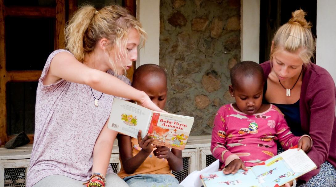 Children read books with Projects Abroad volunteers teaching English in Tanzania