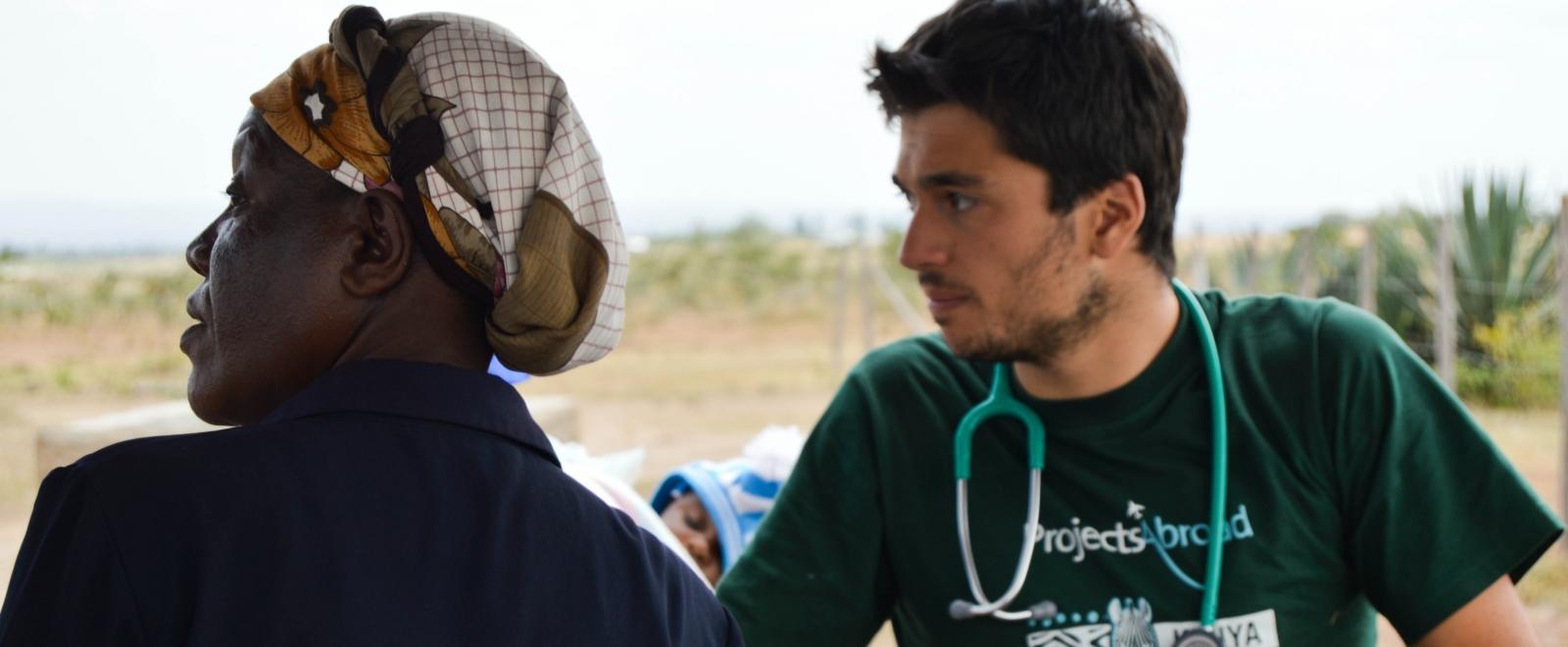 Projects Abroad male intern waits to examine patients at a medical outreach in Kenya. 